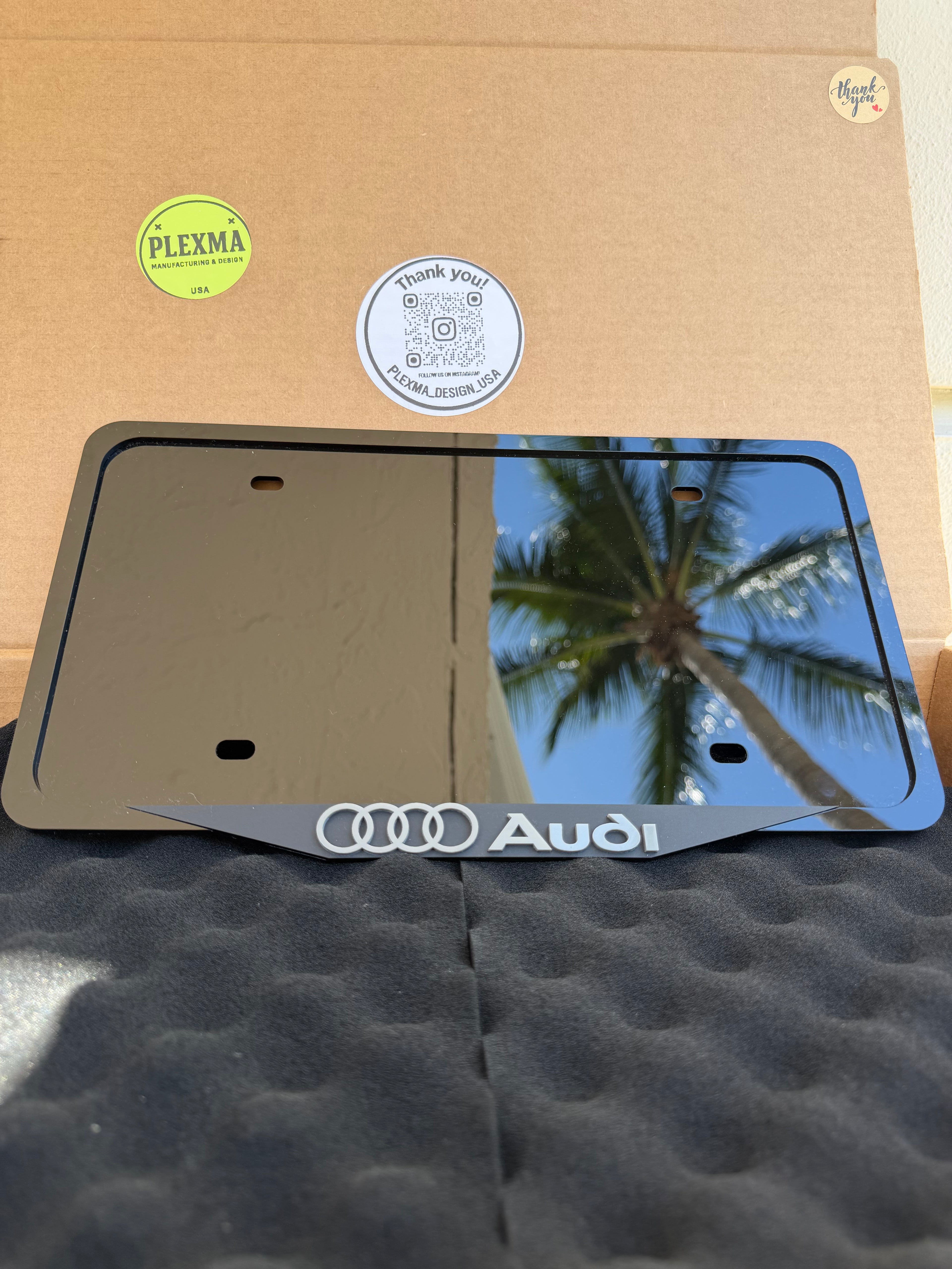 Audi 3D license plate frame with laser-engraved BMW logo, glossy black acrylic, handmade in USA